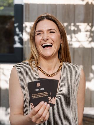 Fleck Founder Anna laughing at camera holding Fleck journal cards