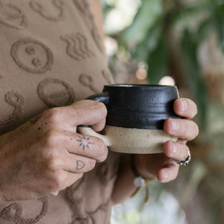 Hands holding a cup of herbal tea