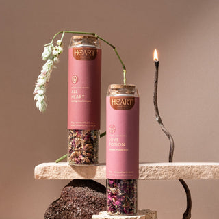 Two jars of All Heart tea beside a lit candle